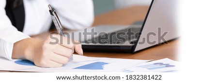 Asian business woman use labtop and note job on paper in office.