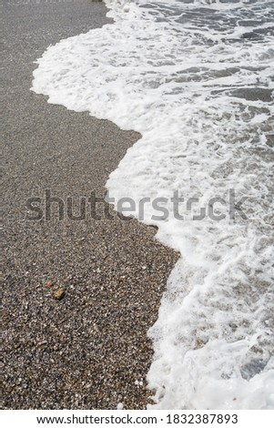 Sea water from a wave with foam on the seashore