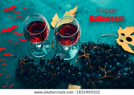 Happy Halloween with wine, funny ghost face, fallen leaves and bats