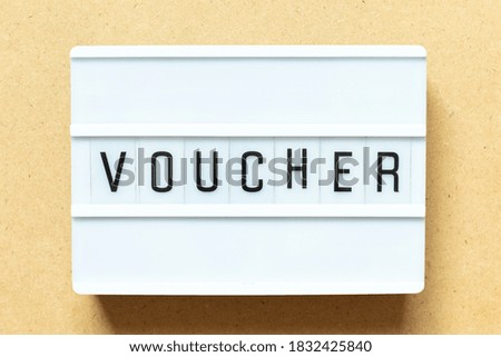 Lightbox with word voucher on wood background