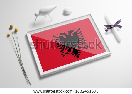 Albania flag in wooden frame on table. White natural soft concept, national celebration theme.