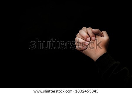 Woman's hand praying and worship to GOD Using hands to pray in religious beliefs and worship christian in the church or in general locations in black background or copy space.