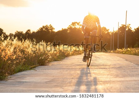Man ride a bicycle at sun set .The image of cyclist in motion on the background in the evening.