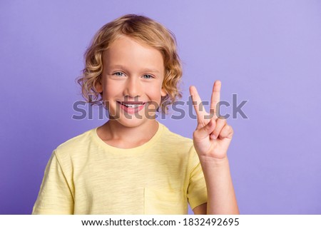 Portrait of charming adorable boy make v-sign toothy smile wear casual style outfit isolated over purple color background