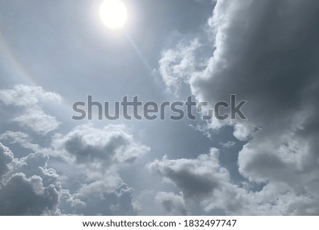 An unusual large gray cumulonimbus cloud and the halo of the sun in the sky.no focus