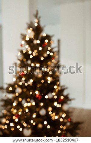 Blurred lights on Christmas tree. Bright glow gold bokeh. Reflections of Christmas lights. Glowing lights.
