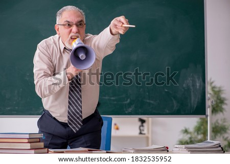 Old male teacher in the classroom Royalty-Free Stock Photo #1832535952