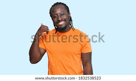 Handsome young african american man wearing casual clothes smiling doing phone gesture with hand and fingers like talking on the telephone. communicating concepts. 