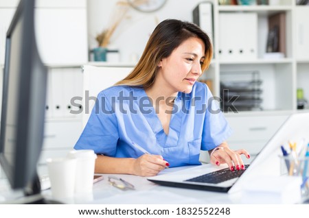 Portrait of young latina female doctor working on laptop in clinic office Royalty-Free Stock Photo #1832552248