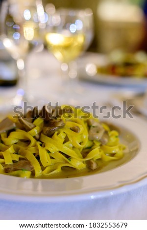 Tasty homemade tagliatelle pasta with fresh harvested boletus porcini mushrooms in creamy sauce close up