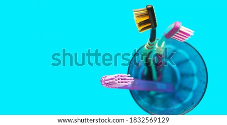 several toothbrushes stand in a glass (top view) on a blue background with space for text                             