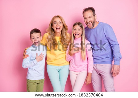 Photo of positive cheerful family looking into camera laughing isolated over pastel color background