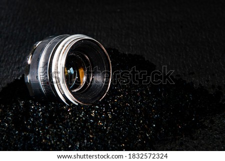 old lens on black sand