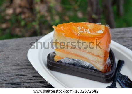 Pice of Chiffon cake with orange jam jelly on wooden plate  Royalty-Free Stock Photo #1832572642