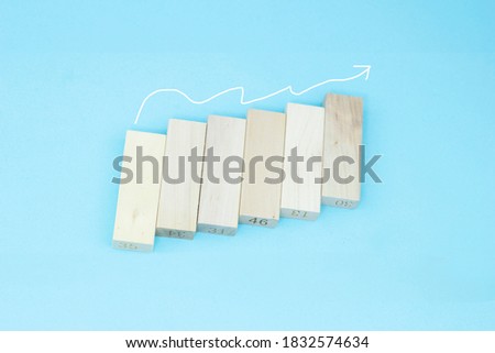 Wooden block stacking as step stair with white arrow up on blue background, Ladder of success in business growth concept, copy space