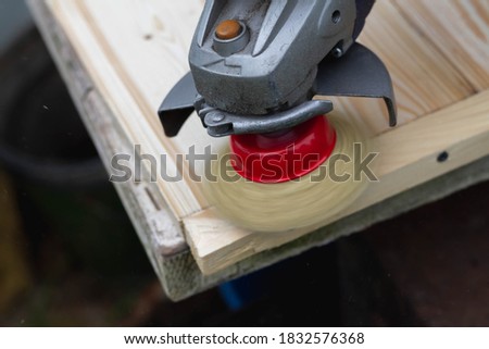Processing of wooden boards by rotating the metal brush head on the saw grinder. Identification of wood texture on wood.