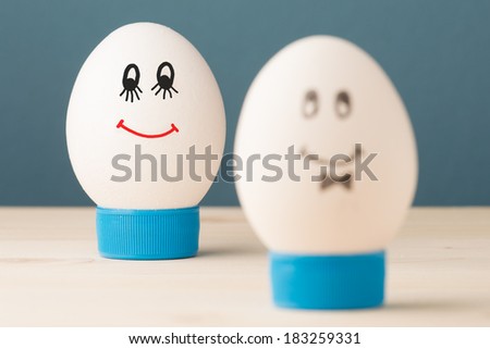 Two white eggs with smiles, male and female, man and woman.