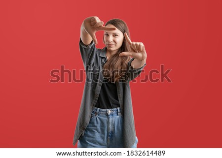 Young caucasian pretty woman making frame with her fingers. Photographer concept