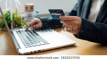 Close up Business woman Hands holding credit card and using laptop for Online shopping,Toned picture,Online shopping,SME, e-commerce, internet banking, spending money,working from home concept.