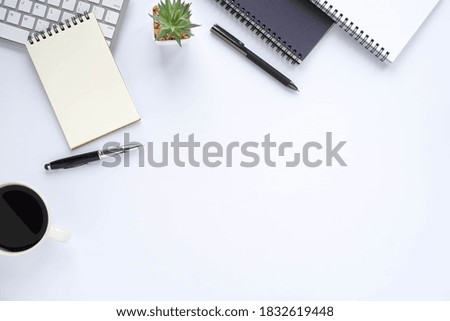 Top view above of White office desk table with keyboard, notebook and coffee cup with equipment office supplies. Business and finance concept. Workplace, Flat lay with blank copy space.