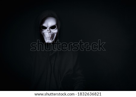 man in spooky dead skull cosplay in black dressed for halloween festival on black background
acting in clamber manner on black background, concept for funny dress halloween festival or carnival.