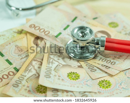 Stethoscope over Thai money, kind of thousound bank note