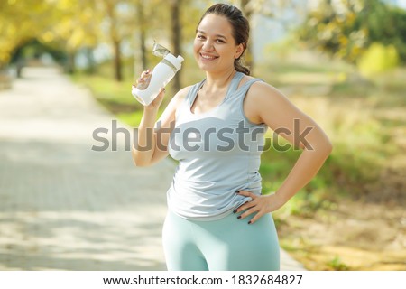 Fat woman and sports. Does exercise for weight loss in the fresh air. High quality photo. Royalty-Free Stock Photo #1832684827