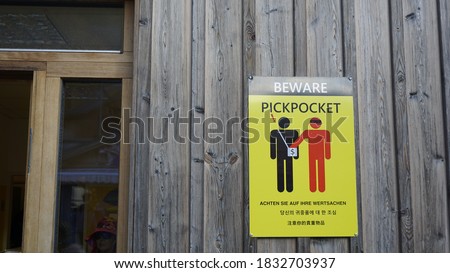 Poster waring sign on the wall in English, German and Chinese language to warn tourist beware pickpocket.