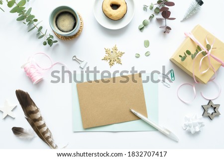 A blank postcard on a white table with a Christmas background. Flat lay, a cup of coffee, a chocolate donat.