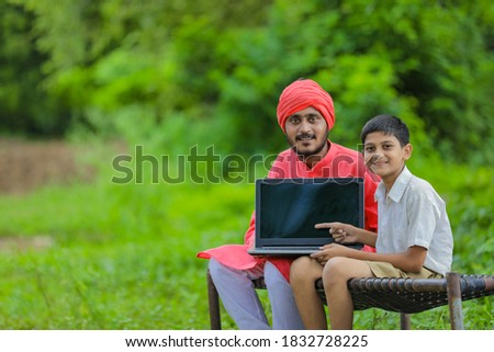 Technology concept : Indian farmer child using laptop