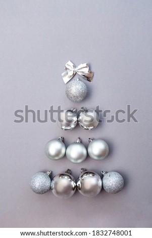 Christmas tree made of silver christmas balls on gray background copy space