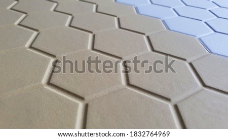 close up of brown and white color of interior hexagon tiles (focused on center of image). trendy interior material tile samples.