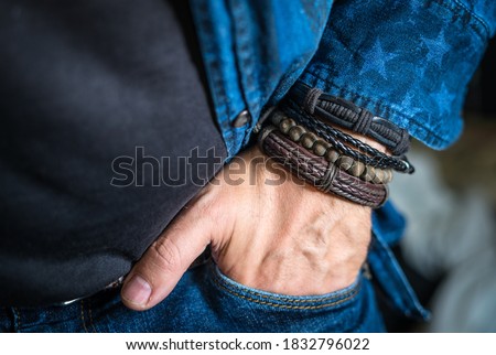 Stylish man wears wrist wooden and leather bracelets Royalty-Free Stock Photo #1832796022