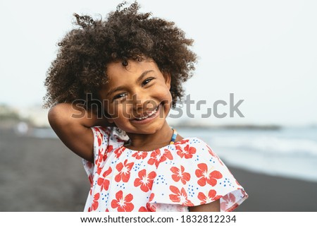 Portrait of Afro American child having fun on the beach during vacation time Royalty-Free Stock Photo #1832812234