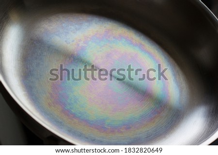 The rainbow stain or "heat tint" on a stainless steel surface of a skillet Royalty-Free Stock Photo #1832820649