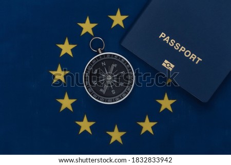 Compass and passport on EU flag close up. Top view