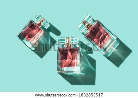 Pattern bottles of woman perfume on a turquoise background, top view, flat lay. Mockup of pink fragrance perfume bottle mockup on turquoise empty background Royalty-Free Stock Photo #1832853517