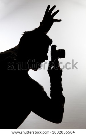 Silhouette of young photographer man