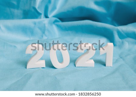 Numbers 2021 on blue fabric background close up