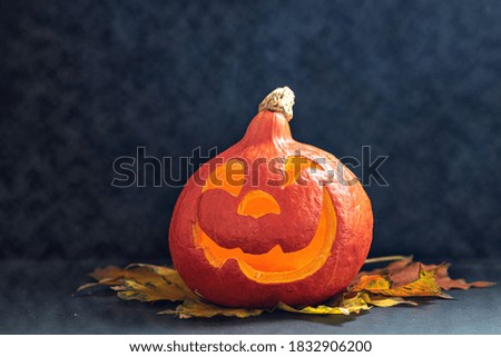 Glowing pumpkin with autumn leaves on a dark background with smoke . Jack's Lantern. Halloween
