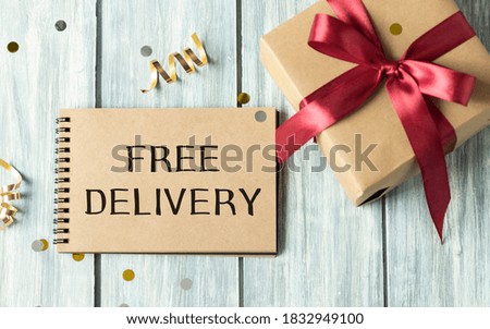 Free delivery concept: a parcel brought by hand with free delivery text