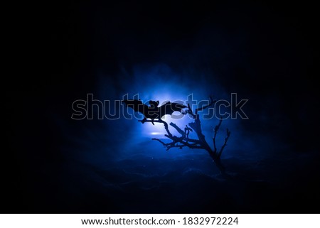 Scary view of zombies at cemetery dead tree, bat and spooky cloudy sky with fog, Horror Halloween concept. Selective focus