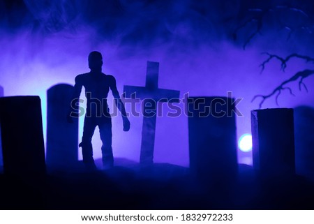 Scary view of zombies at cemetery dead tree, moon, church and spooky cloudy sky with fog, Horror Halloween concept. Selective focus