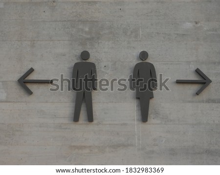 Signs on the marble wall that shows the directions to male and female restrooms
