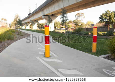 Parking space protector. Yellow and red path way bollards.