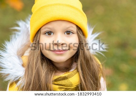Portrait of a little girl in a yellow hat.