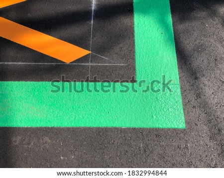 Green traffic perpendicular line on black asphalt street.Dark tarmac texture with green line.