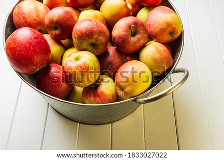 Ripe red apples and watermelon in washtub on white wooden background top view