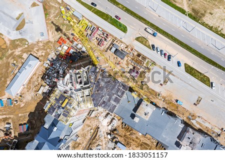 busy construction site. crane, construction materials and machinery. aerial drone photo looking down