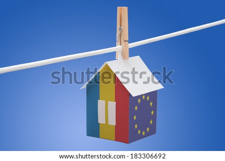 concept - Romania, Romanian and EU flag painted on a paper house hanging on a rope